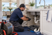 Sink Repair in Windermere plumber clearing a clogged kitchen sink drain in a Central Florida home